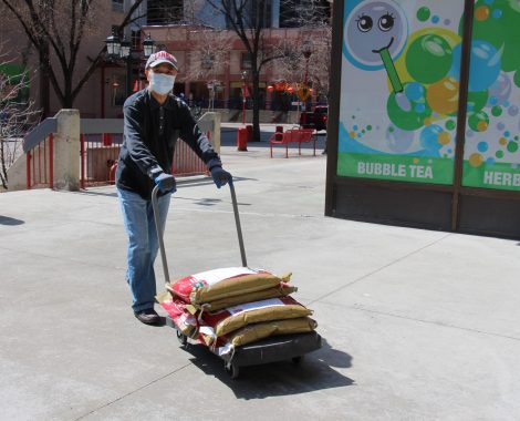 A volunteer delivering rice packages by cart